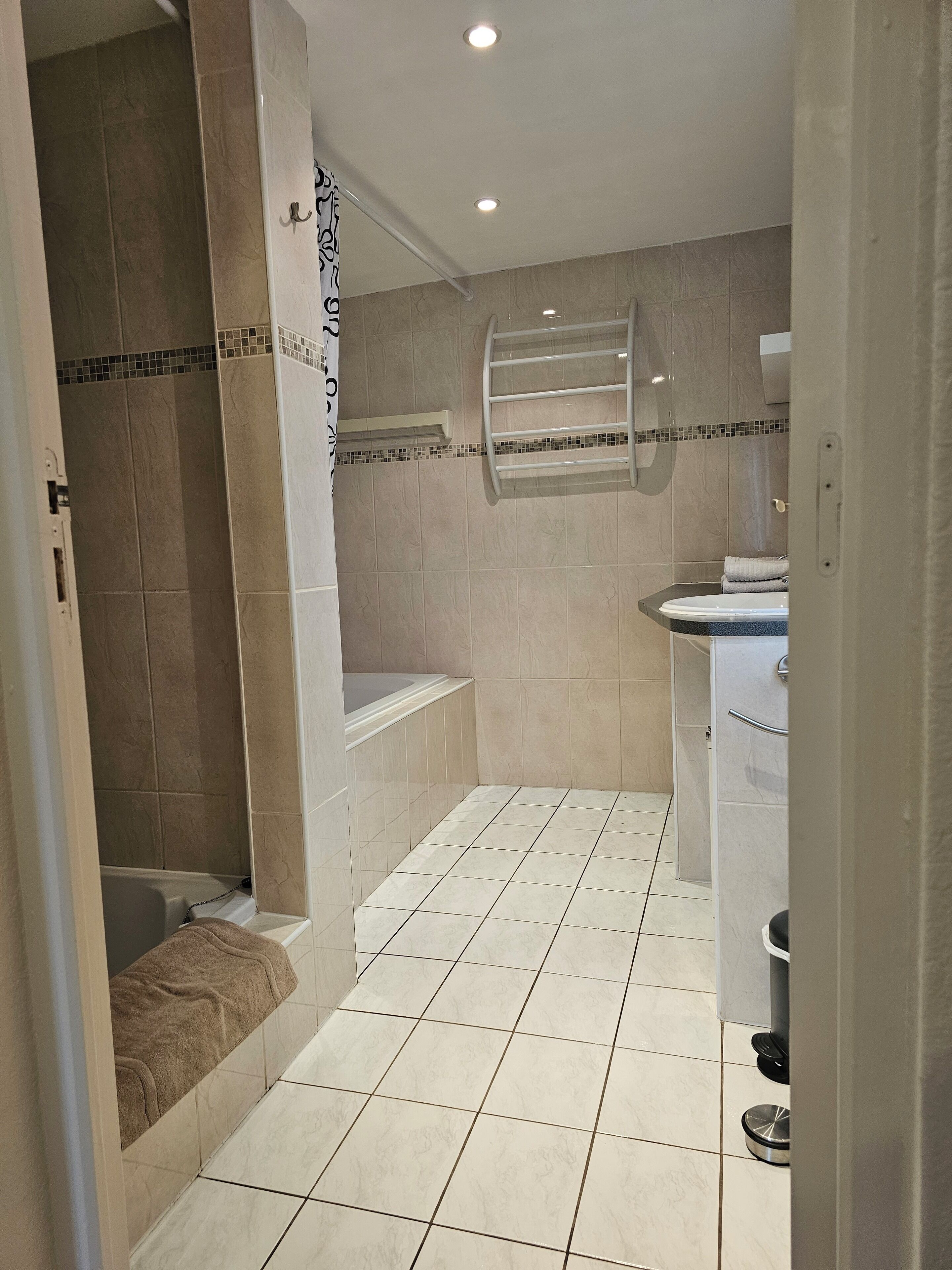 Een badkamer met een douche, bad en toilet.