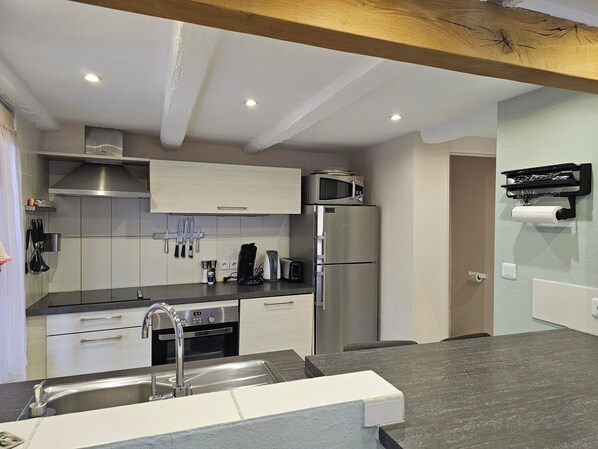 A modern kitchen with stainless steel appliances, a built-in oven, and a microwave.