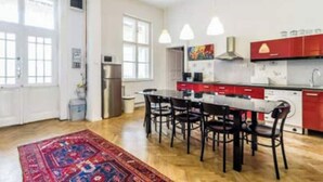 Une cuisine moderne dotée d’un îlot central, de tabourets de bar et d’un appareil électroménager rouge.