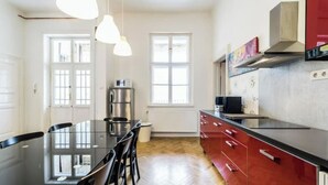 Une cuisine moderne dotée d’un îlot central, de meubles de couleur rouge et de luminaires suspendus.