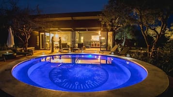 Una piscina al aire libre, sombrillas, tumbonas