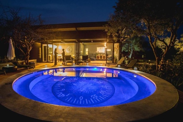 Una piscina al aire libre, sombrillas, tumbonas