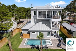 A two-story house with a large deck and a swimming pool. - Ash in the Sand - Private Pool / Golf Cart / 6 Bikes / Game Room (Santa Rosa Beach)