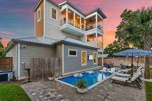 A two-story house with a backyard pool and outdoor seating area. - Ash in the Sand | 30A | Privte Pool | Golf Cart | Bikes | Games (Santa Rosa Beach)