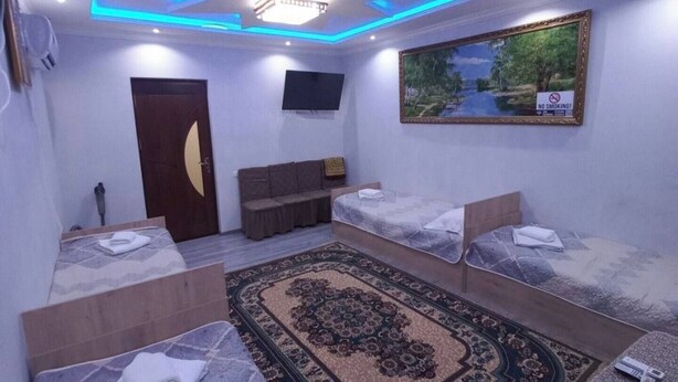 Una camera d'albergo con soffitto a forma di stella, un tappeto grande e un letto con testiera.