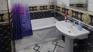 Un bagno con una vasca, un lavandino e una doccia.