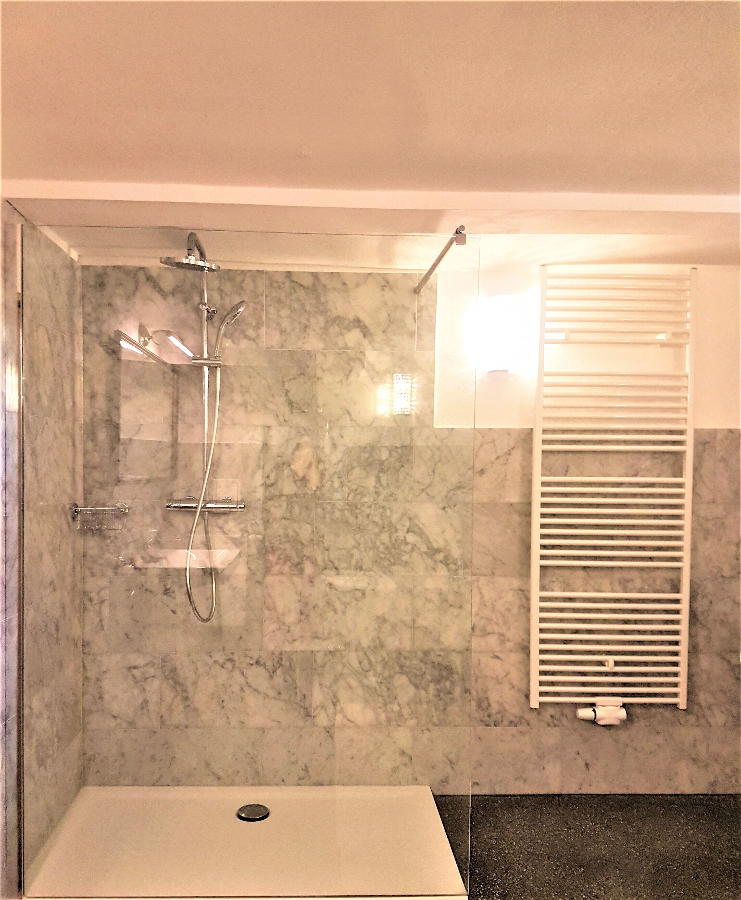Een badkamer met een douche, toilet en wastafel.