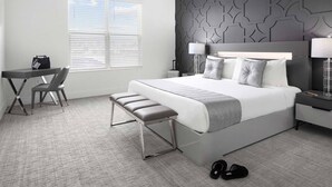 Une chambre d’hôtel moderne avec un grand lit, un bureau et une chaise.