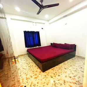 Relax in this stylish bedroom with a large bed and ceiling fan.