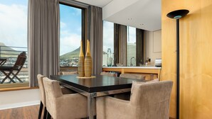 A modern dining area with a large table, cushioned chairs, and a view of a cityscape. - Cartwrights Corner 1403 (Cape Town)