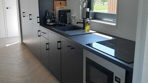 Eine moderne Küche mit eingebauten Geräten, einem Fenster und Blick ins Freie.