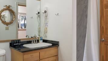 Une salle de bain équipée d’un meuble-lavabo, d’un évier, d’un miroir et de luminaires.