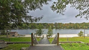 A pathway leading to a lake with a view of houses and trees in the background. - Poconos Chalet Newly Renovated, Great Location 3 Bedroom Home by RedAwning (Tobyhanna)