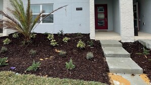 A modern two-story house with a red door, numbered 1094, and a landscaped front yard with mulch and small plants. - 1094ssp-the Retreat At Championsgate 4 Bedroom Home by RedAwning (Davenport)