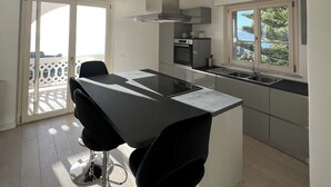 A modern kitchen with a central island, stainless steel appliances, and a view of the outdoors. - The perfect place for your dream holiday (Lucerta)