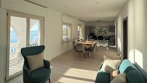 A spacious living area with a sofa, armchair, and dining table. - The perfect place for your dream holiday (Lucerta)