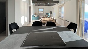 A modern kitchen with a central island, a dining area with a large table, and a view of the outdoors. - The perfect place for your dream holiday (Lucerta)