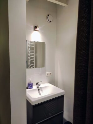 Ein Badezimmer mit Waschbecken, Spiegel und Handtuchhalter.