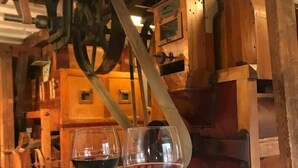 Dos copas de vino sobre una mesa blanca con un fondo de madera rústica.