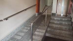 Escada com guarda-corpos de metal e degraus de pedra.