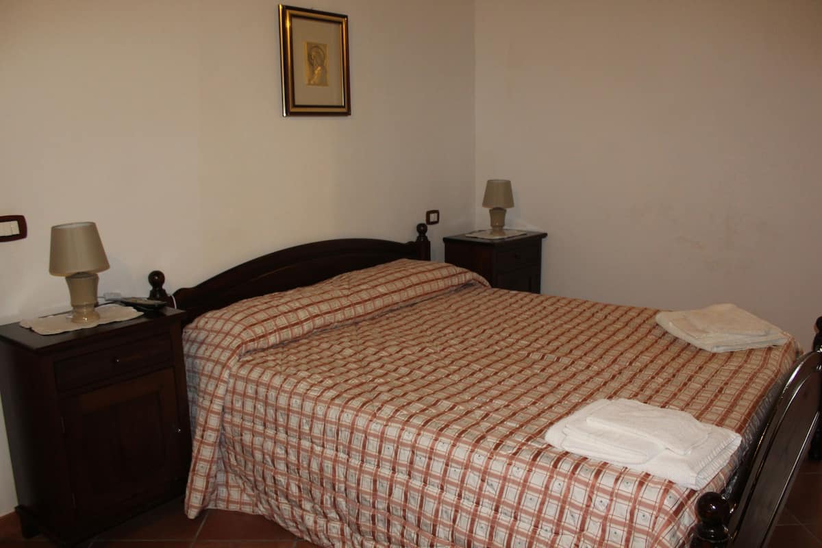 A bedroom with a bed, two bedside tables, and a nightstand.