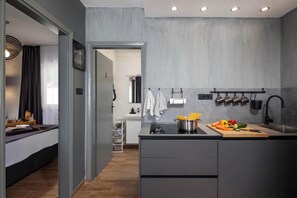 Una cocina moderna con encimera gris, un fregadero y diversos utensilios de cocina.