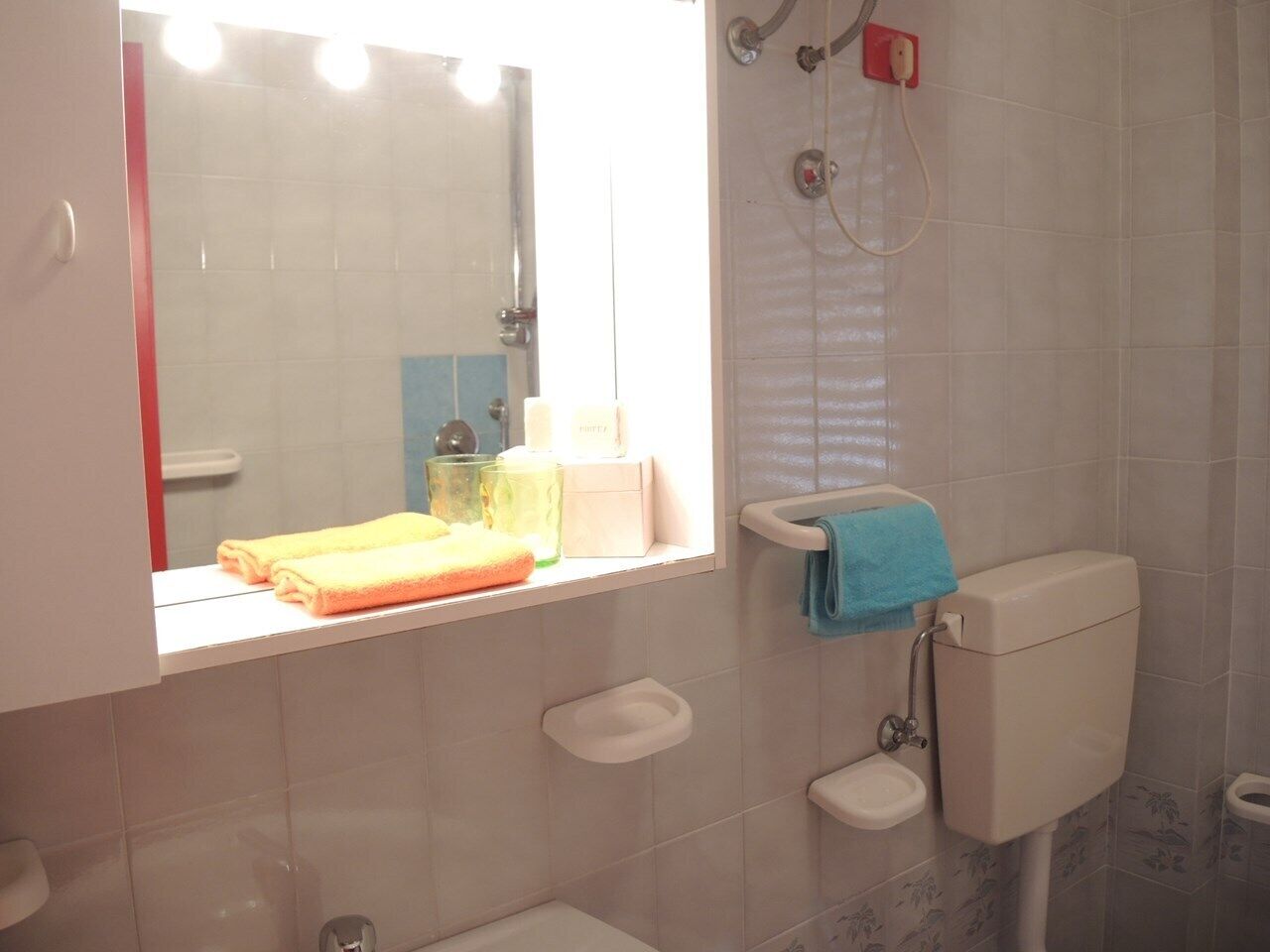 A bathroom with a toilet, bidet, and a window with a towel rack.