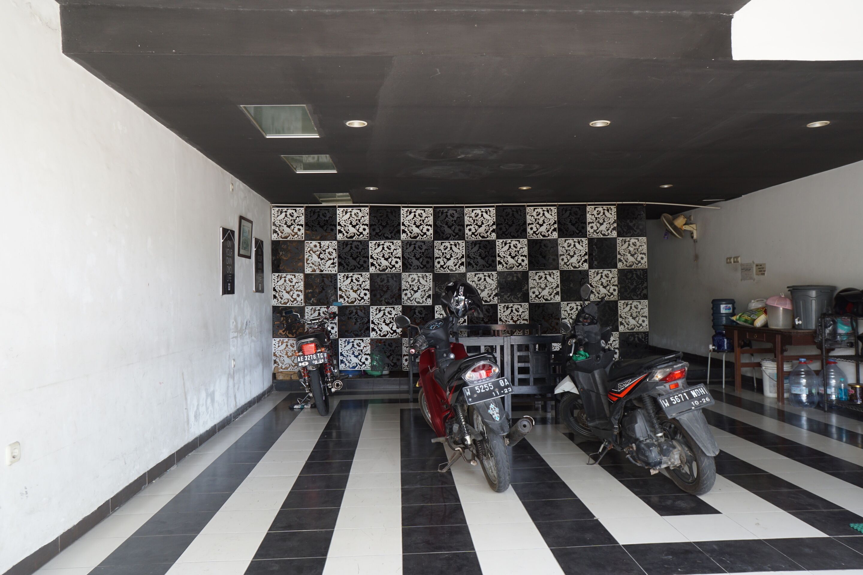 A motorcycle parking area with tiled flooring and a checkered wall pattern.