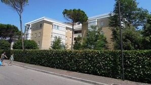 A multi-story residential building with a flat roof and a brick facade. - Delightful Apartment in Bibione (San Michele al Tagliamento)