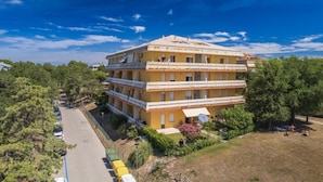A multi-story building with balconies, surrounded by trees and a parking area. - Seaside Flat With Terrace - Beahost Rentals (San Michele al Tagliamento)