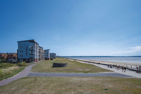 A coastal building with a paved walkway leading to the beach. - Swn Y Mor - 4 Bedroom - Llanelli (Llanelli)