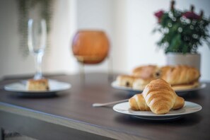 A dining table with plates of croissants and a glass of wine. - Swn Y Mor - 4 Bedroom - Llanelli (Llanelli)