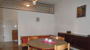 A dining area with a round wooden table, four chairs, and a cabinet. - Peaceful Villa With Garden 500mt From the sea (San Michele al Tagliamento)