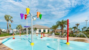 Un parque acuático con piscina, atracciones acuáticas coloridas y palmeras.