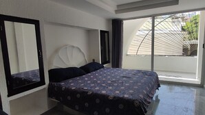 A bedroom with a bed, a large mirror, and a sliding glass door leading to a balcony. - Villa 5 minutes from the sea with parking (Acapulco de Juárez)