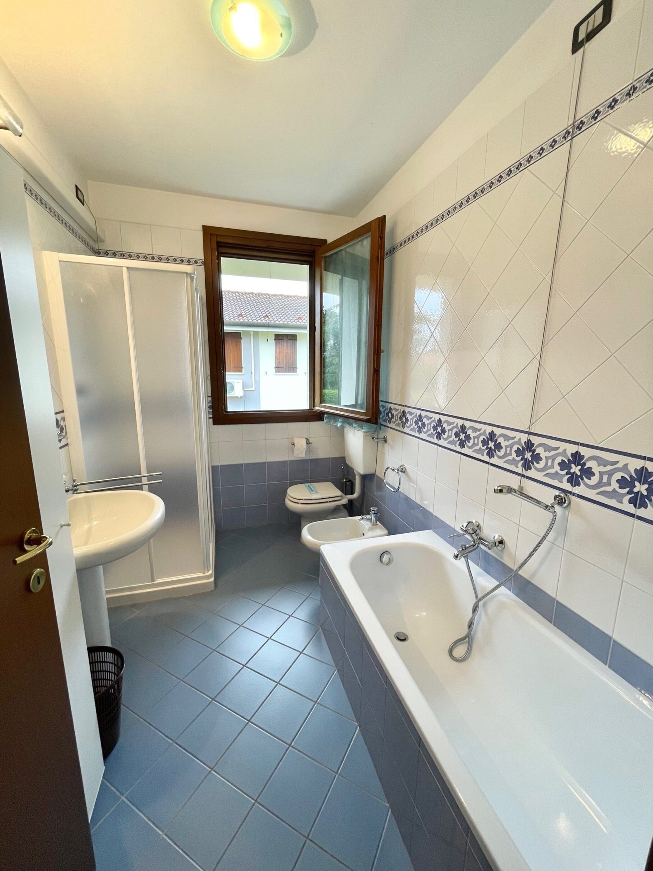 A bathroom with a shower, toilet, bidet, and bathtub.