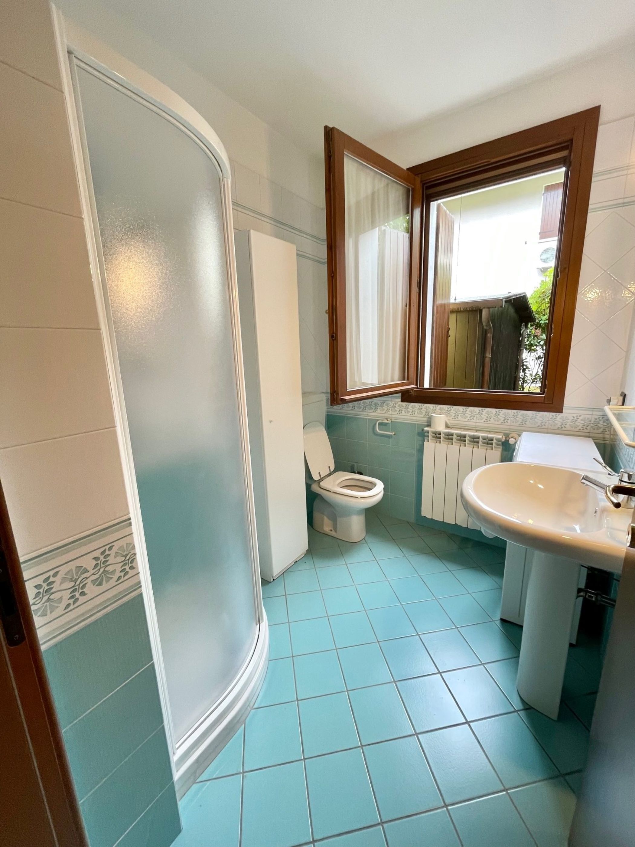 A bathroom with a shower, toilet, and sink.