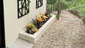 Een gebouw met een naamplaatje 'ANGARA' en een tuin met planten en een pad.