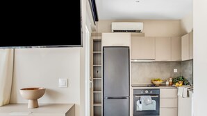 Une cuisine compacte dotée d’un réfrigérateur, d’un four et d’un petit plan de travail intégrés.