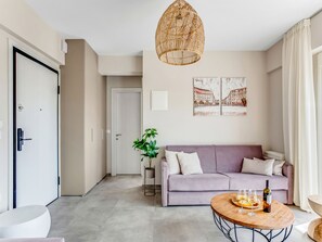 Un salon moderne avec un canapé, une table basse et un luminaire suspendu.