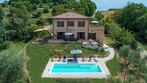 A two-story house with a swimming pool, surrounded by greenery and a paved deck. - Casa Eusebia 8+2, Emma VIllas (Città della Pieve)