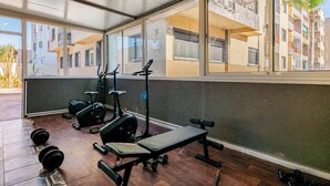 Een buitengymnastiek met trainingsapparatuur, een bank en gewichten.