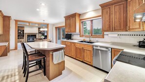 A modern kitchen with wooden cabinets, a central island, and a dishwasher.