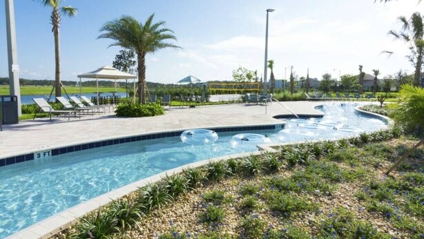 A swimming pool with lounge chairs and a covered area. - Brand new Fantastic Home at Storey Lake (Kissimmee)