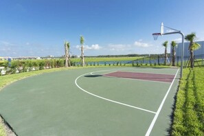 An outdoor basketball court with a green surface, a red key area, and a basketball hoop. - Enchanting Decor Home With Private Pool (Kissimmee)