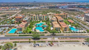 A resort with multiple buildings, swimming pools, and a beach area.