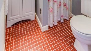 Un baño con lavamanos, espejo e inodoro blancos.