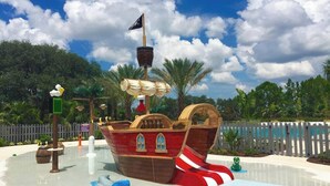 A pirate ship-themed water play area with slides and a ship-shaped pool. - Beautiful Townhome W/pool Close to Disney (Davenport)