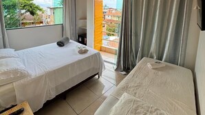 Una habitació d'hotel amb dos llits, televisió, aire condicionat i vista a l'exterior.