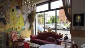 Una habitación con un ventanal grande, un sofá rojo y una mesa con sillas.